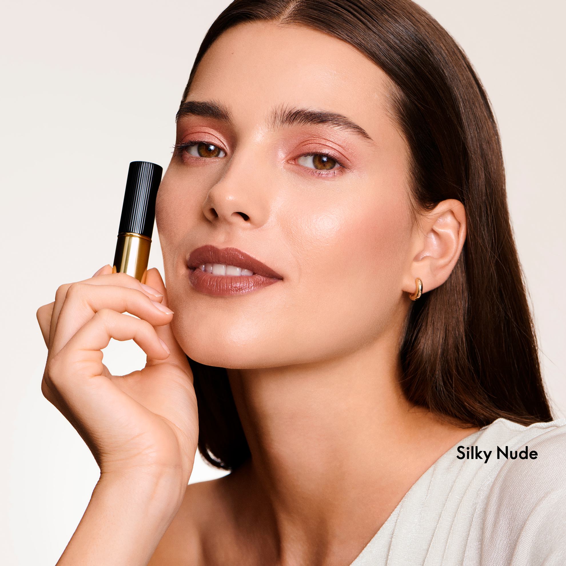 Một phụ nữ cầm một tuýp son môi