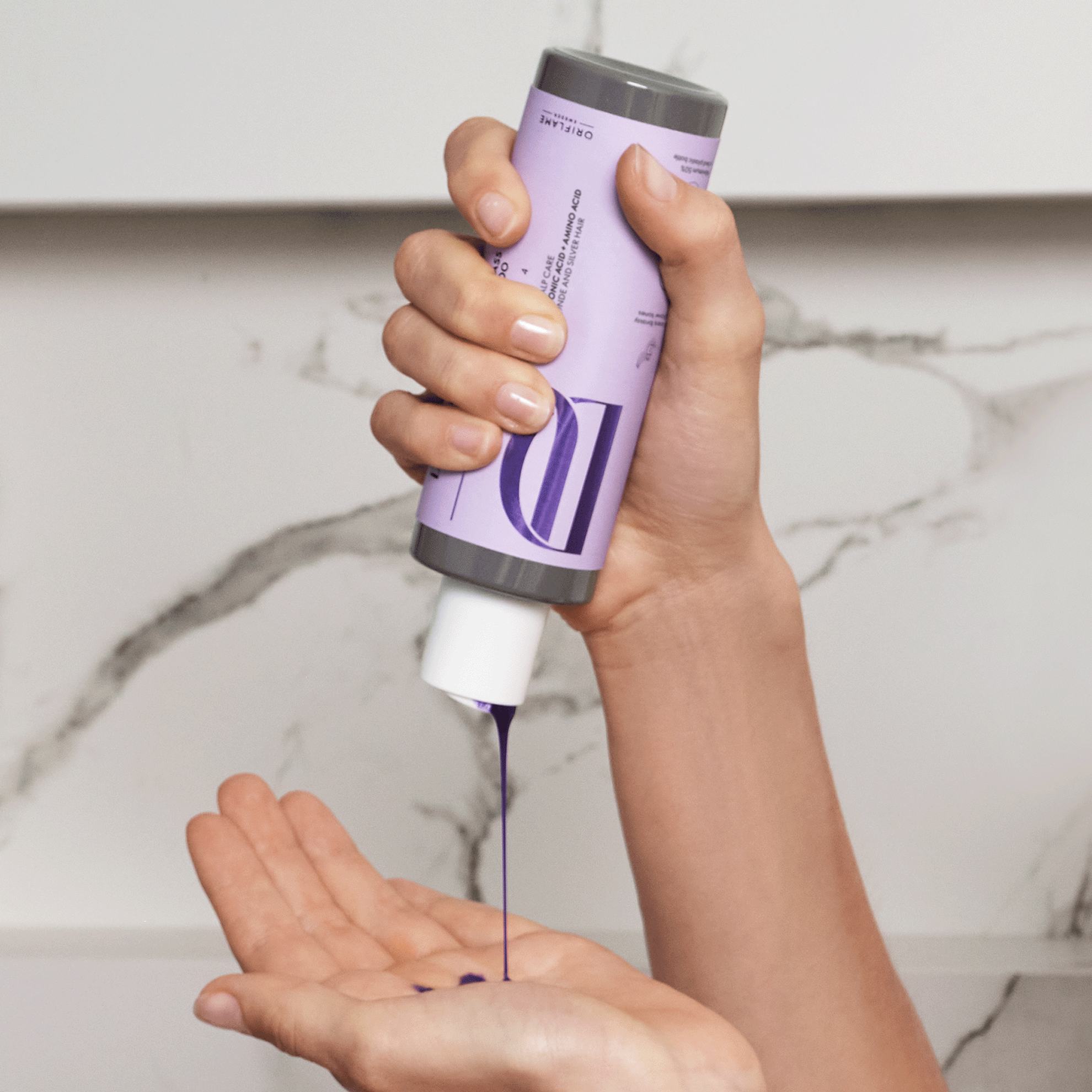 Một người đang đổ chất lỏng màu tím lên tay.