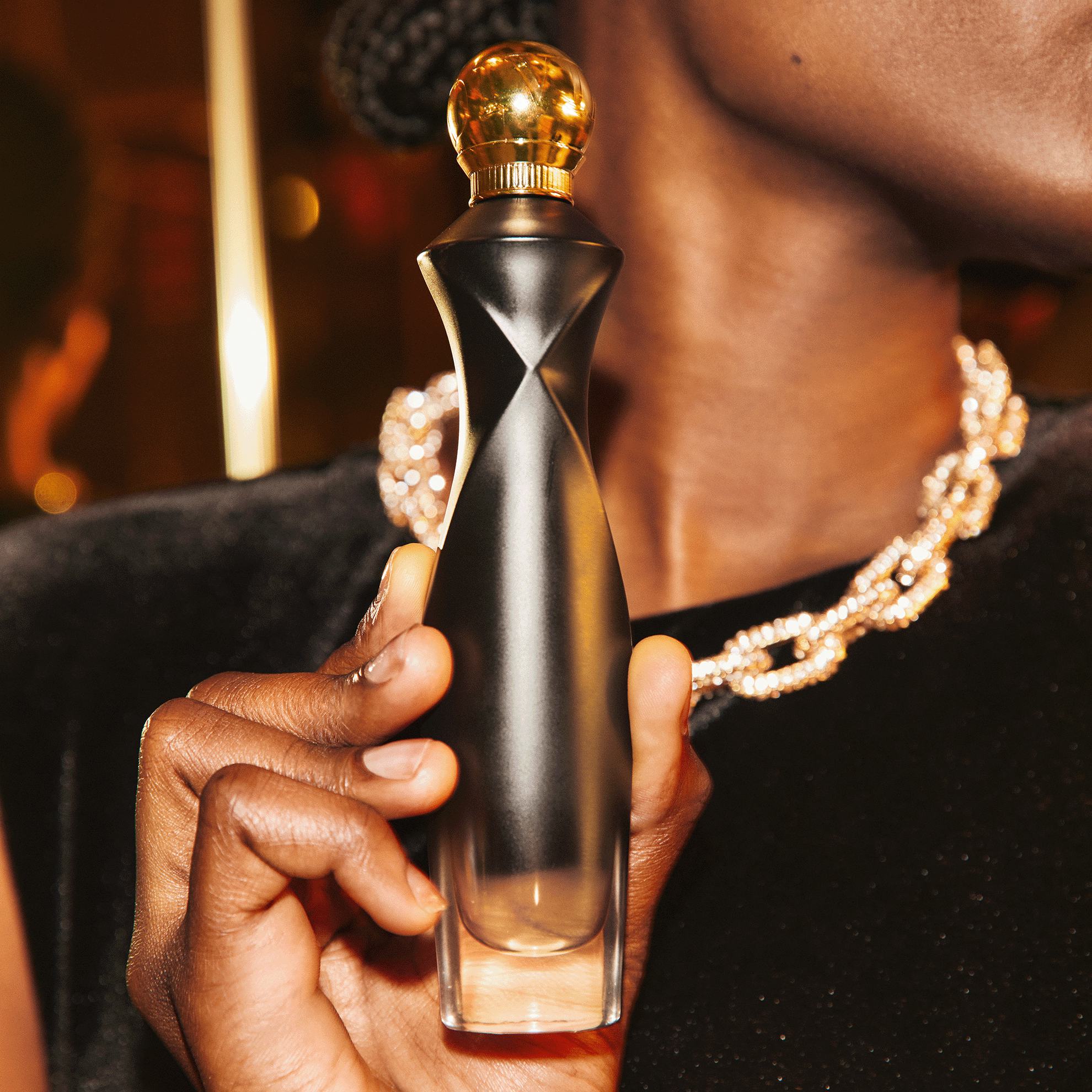 một phụ nữ đang cầm một chai nước hoa