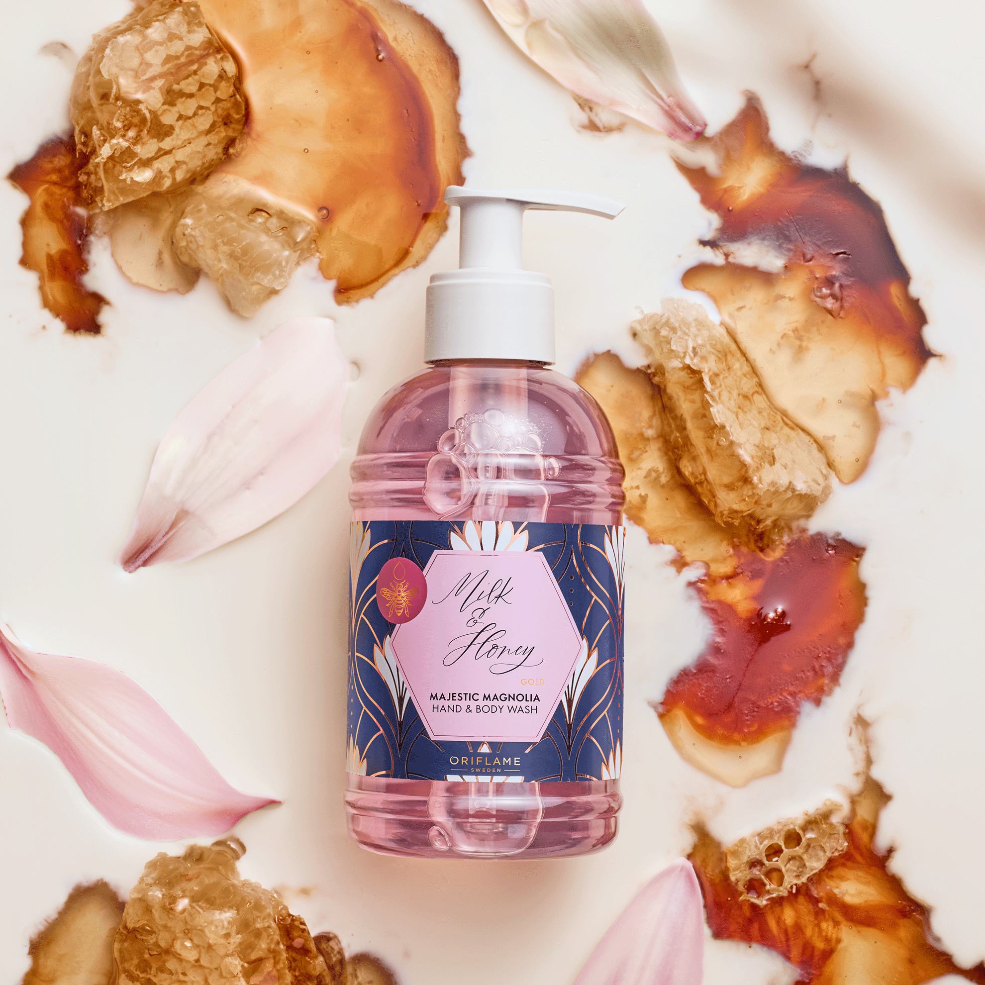 Một chai chất lỏng trên bề mặt trắng với những cánh hoa nâu.