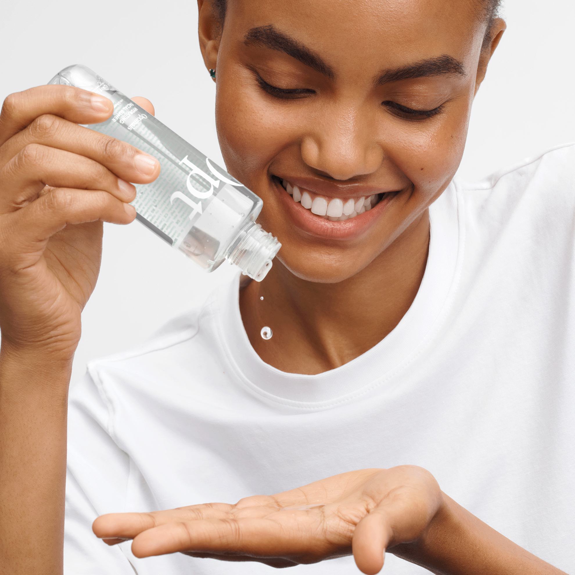 một người phụ nữ đang đổ một chai chất lỏng lên tay