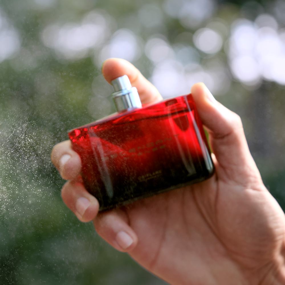 một người đang xịt một chai màu đỏ