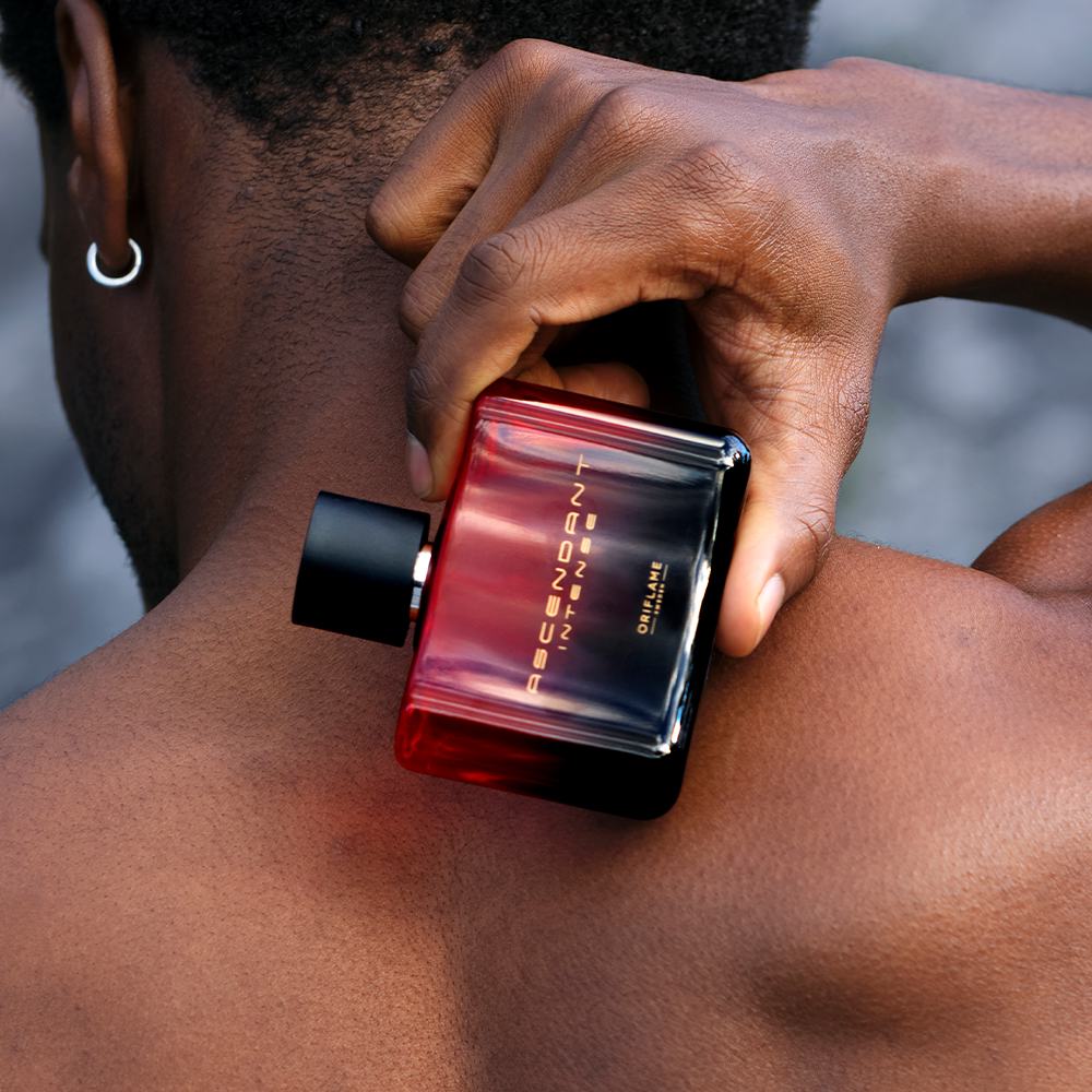 một người đàn ông cầm một chai nước hoa