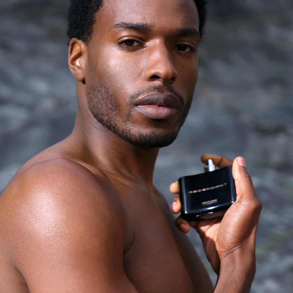 một người đàn ông cầm một chai nước hoa