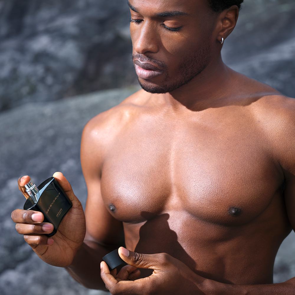 một người đàn ông cầm một chai nước hoa