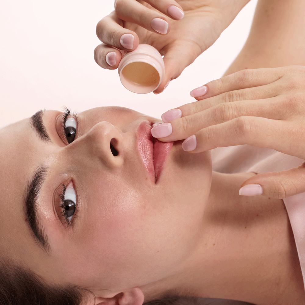 một phụ nữ đang thoa son dưỡng môi