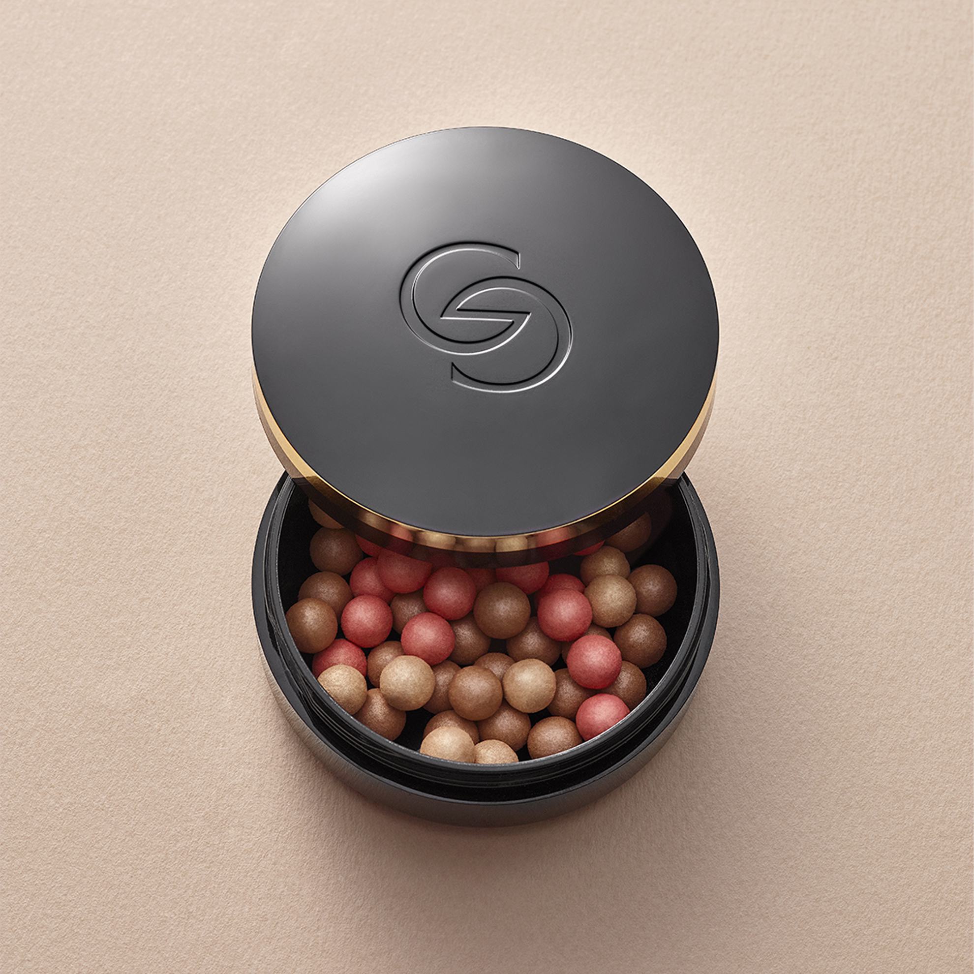 Một hộp đen có hình tròn chứa đầy các viên phấn má hồng.