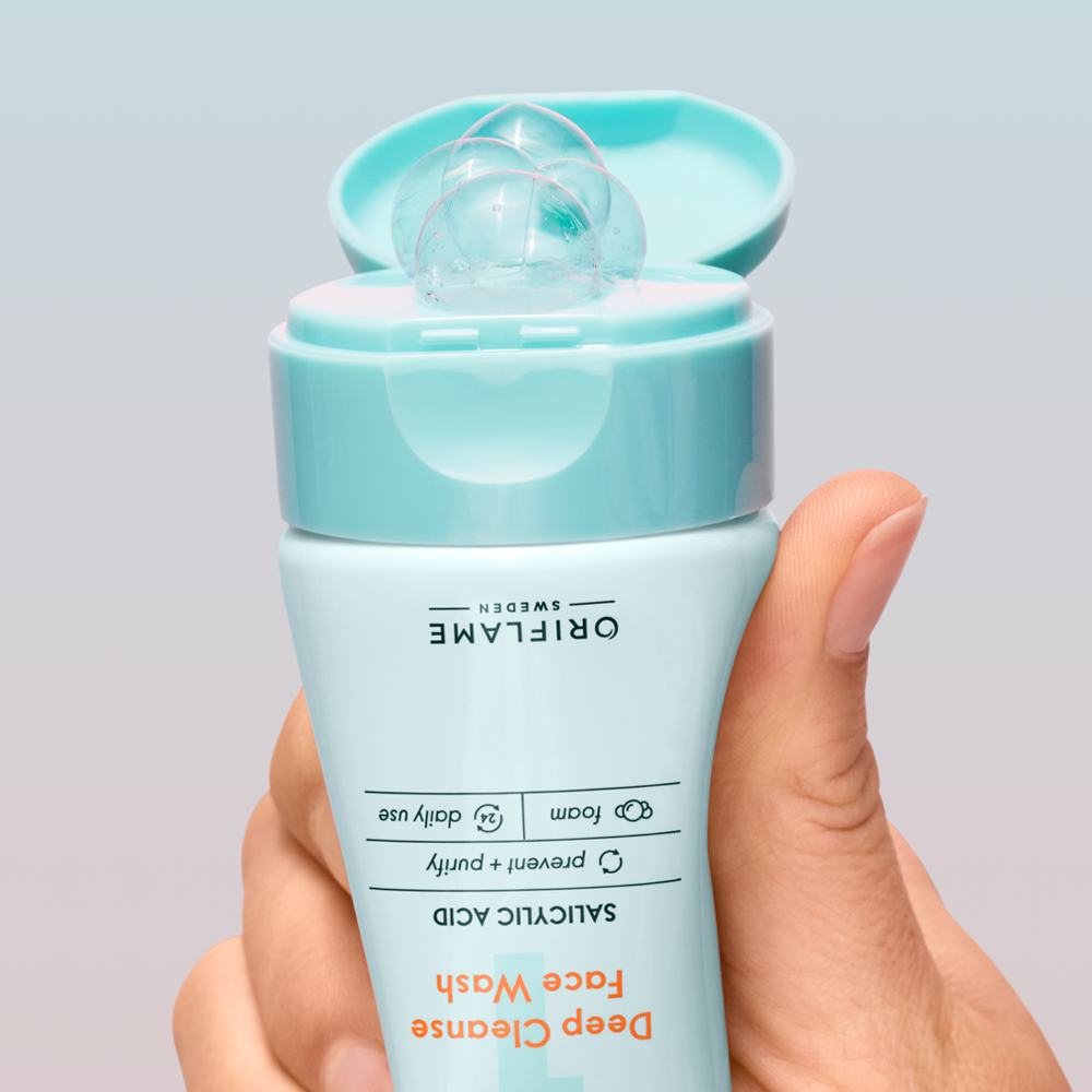 Một bàn tay cầm chai sữa rửa mặt nhỏ