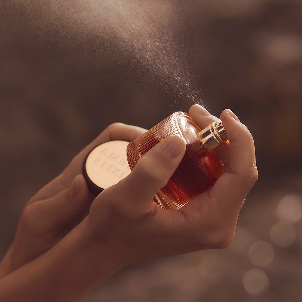 một người đang xịt nước hoa vào lọ