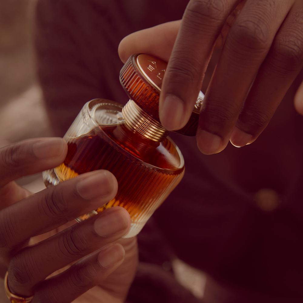 một người đang cầm một chai nước hoa