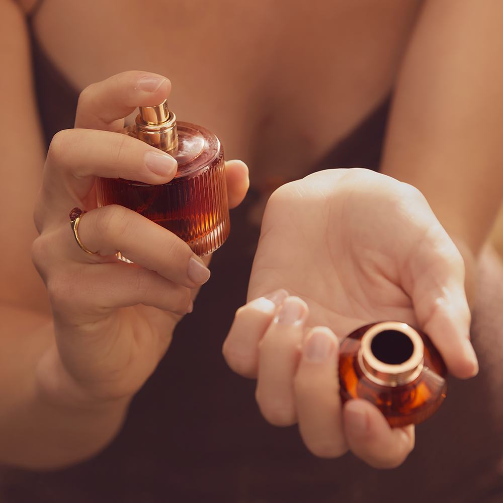 một người phụ nữ đang cầm một chai nước hoa