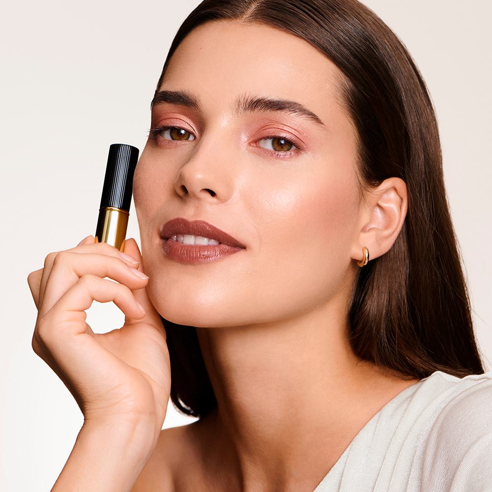 Một phụ nữ cầm một tuýp son môi