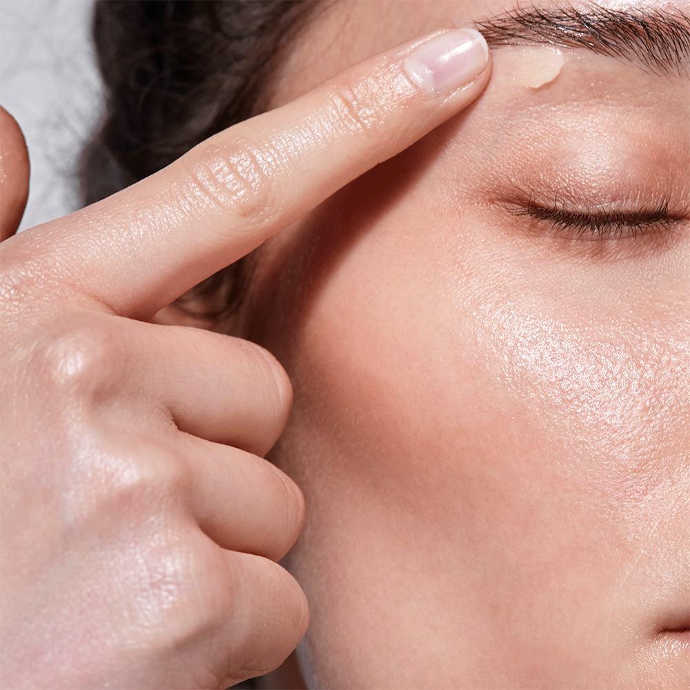 một người đang nhỏ một giọt dầu lên trán