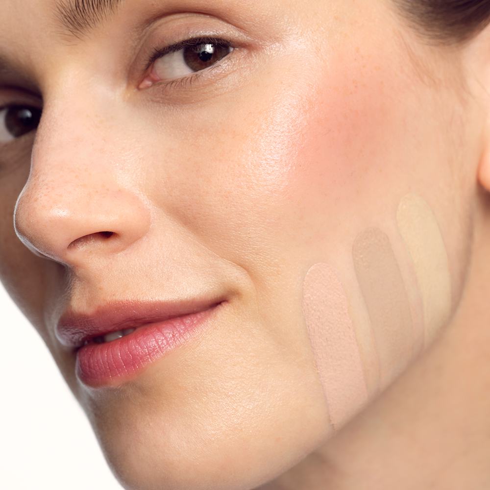một người phụ nữ với các tông màu trang điểm khác nhau trên khuôn mặt