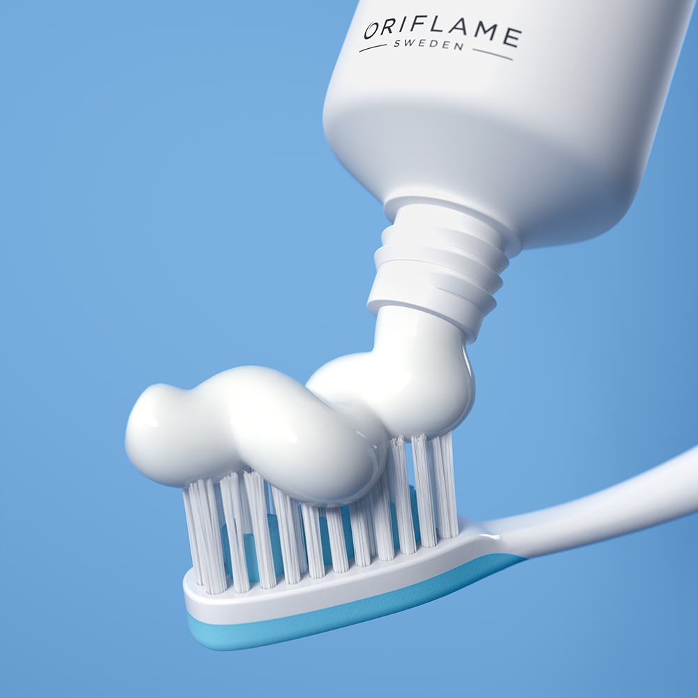 một tuýp kem đánh răng đang được bóp ra bàn chải đánh răng