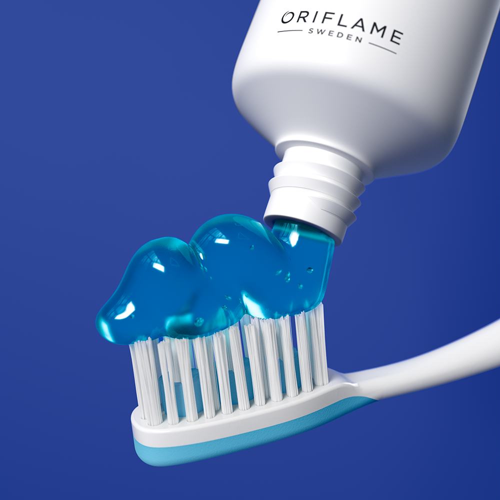một tuýp kem đánh răng đang được bóp ra bàn chải đánh răng